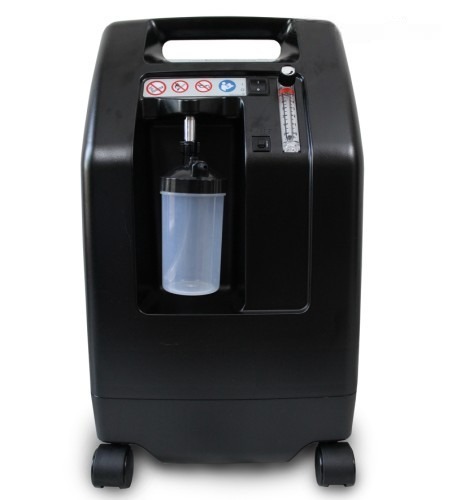 DeVilbiss 5 LPM oxygen concentrator — front view with humidifier bottle fitted and flow meter on the control panel